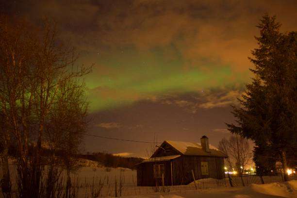 Night sky with aurora over a cabin, perfect for an inviting exterior wall light.