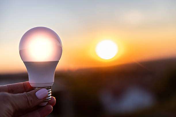 Hand holding a bright LED bulb, useful as an energy-efficient wall light or ceiling fixture.