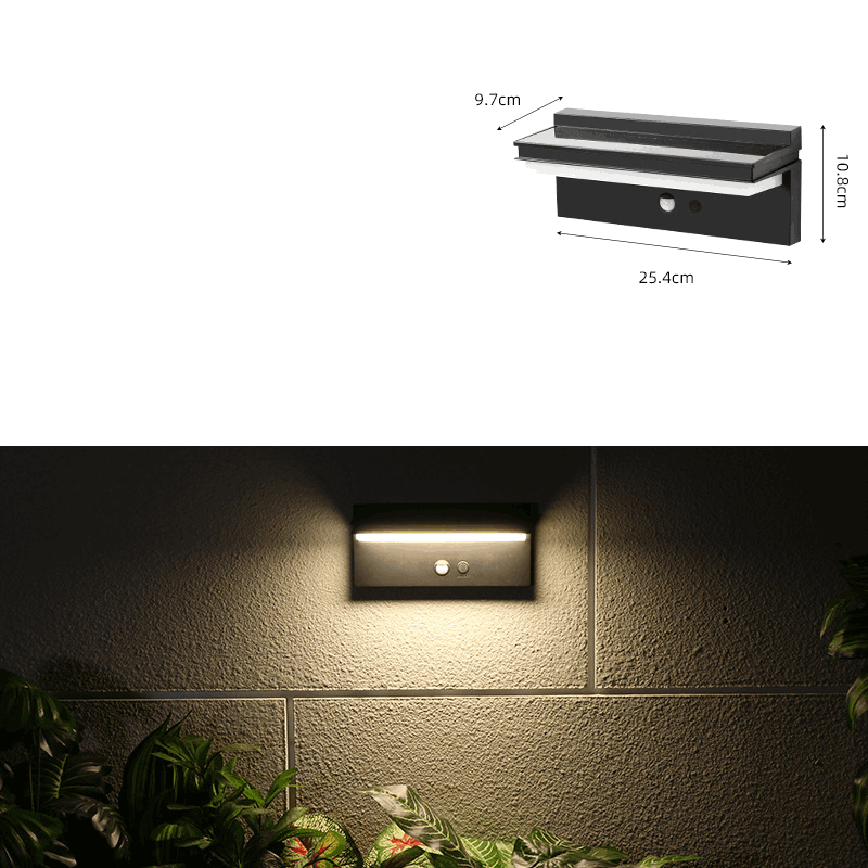Modern black outdoor wall light with sensor, casting warm light on a textured wall.